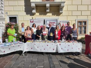 Gruppe mit Büchern in der Hand, alle der Kamera zugewandt, vor dem Rathaus in Eisenstadt